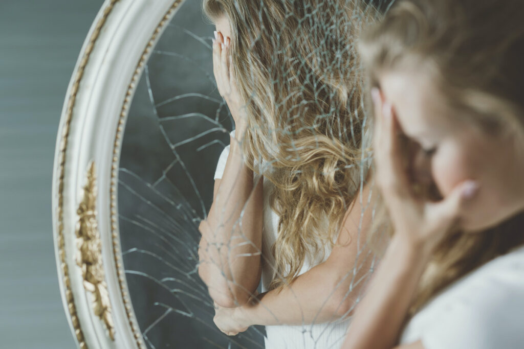 femme devant un miroir brisé