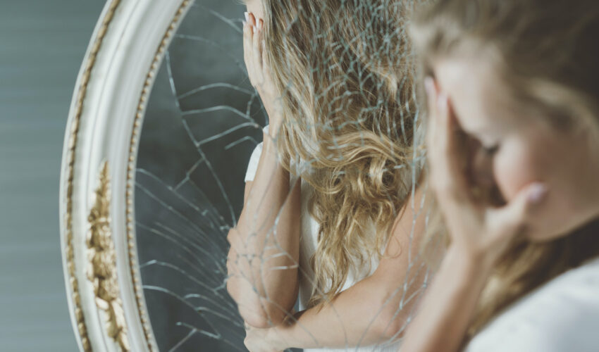 femme devant un miroir brisé