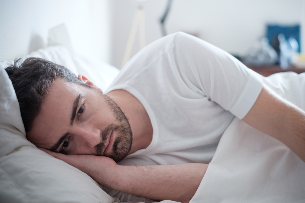 homme qui réfléchie dans son lit