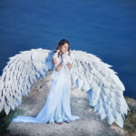 un ange aux ailé dos à l'océan