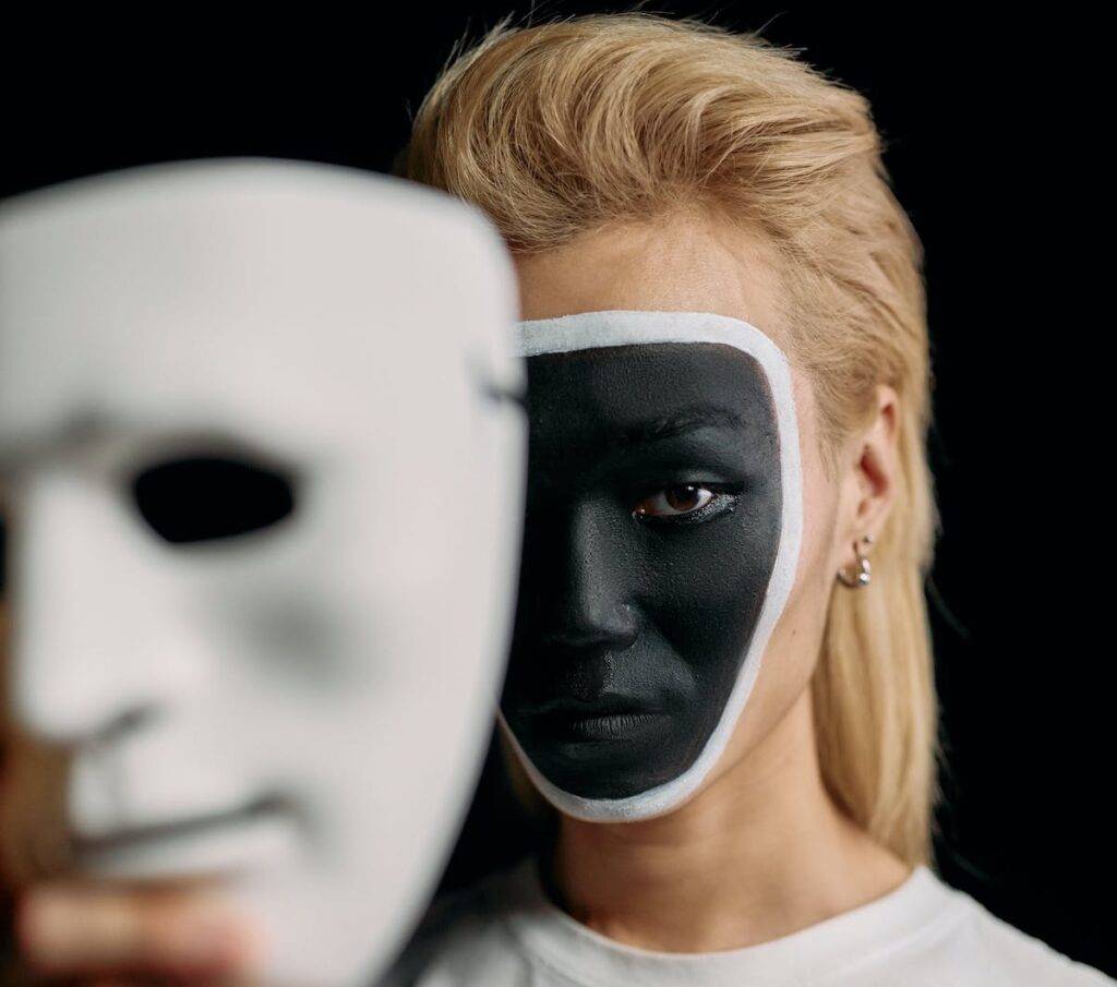 Hommen tenant un masque devant son visage