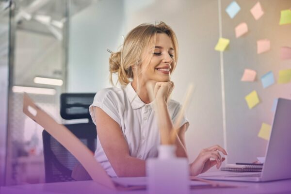 belle-femme-affaires-travaillant-ordinateur-portable-souriante-assise-table-au-bureau