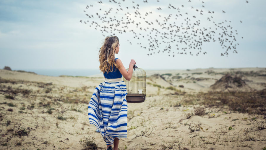 femme libérant des oiseaux de leur cage