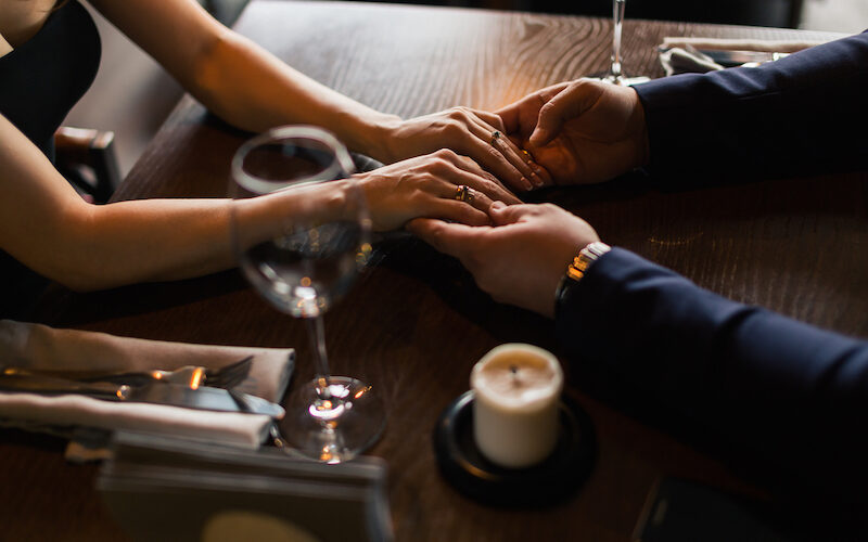 couple se tenant la main au restaurant