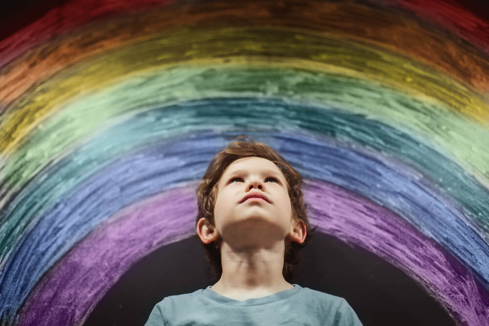 enfant qui regarde un arc-en-ciel