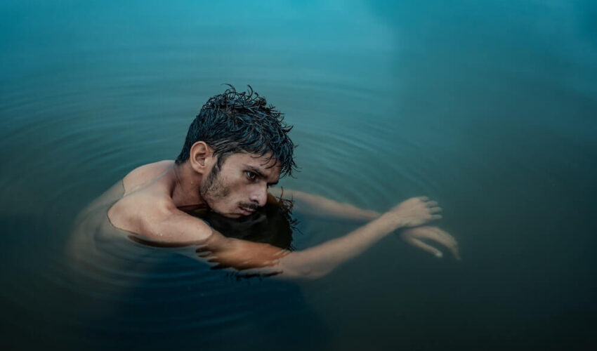 homme recroquevillé dans l'eau