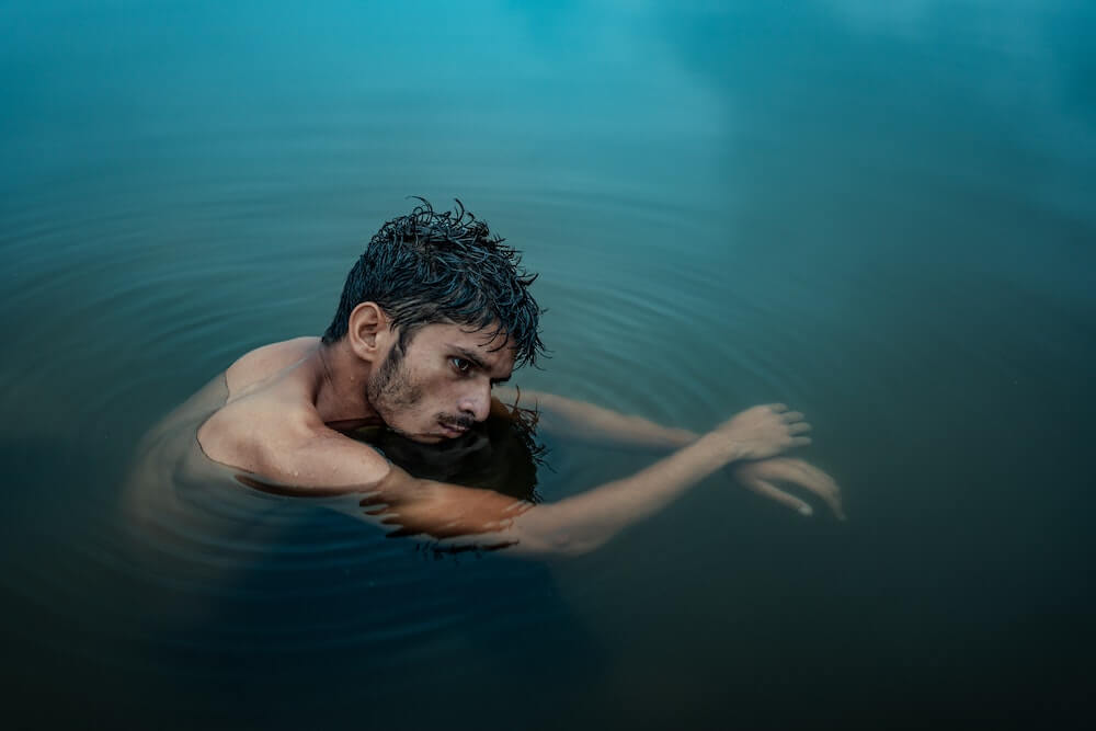 homme recroquevillé dans l'eau