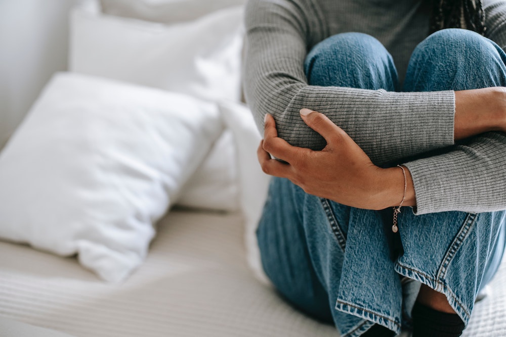 femme triste assise sur un lit