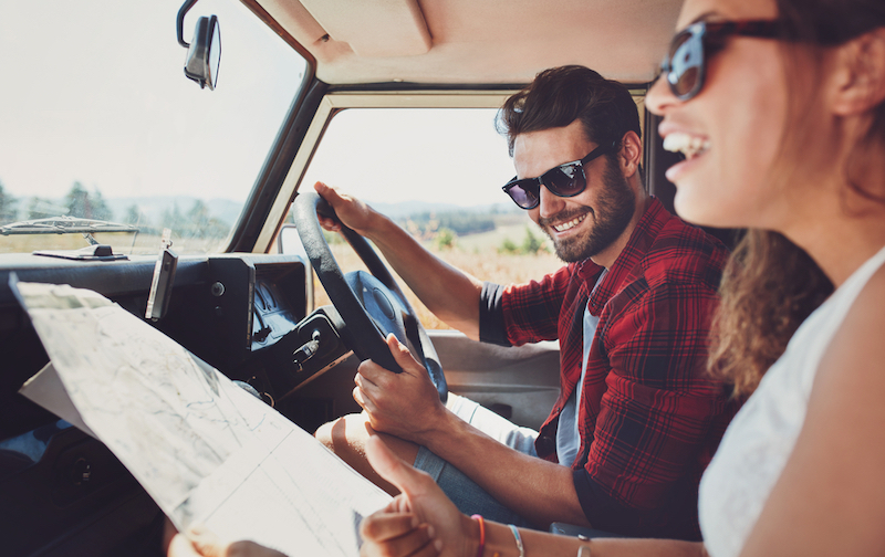 jeune couple avec une carte dans la voiture