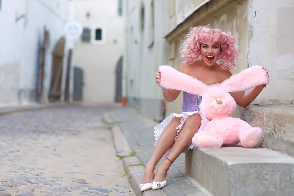 femme vetue de rose tenant une peluche