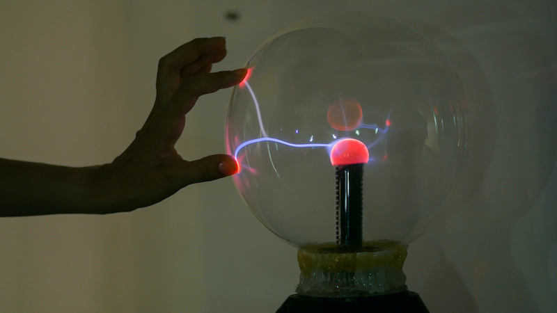 Femme qui touche une boule plasma