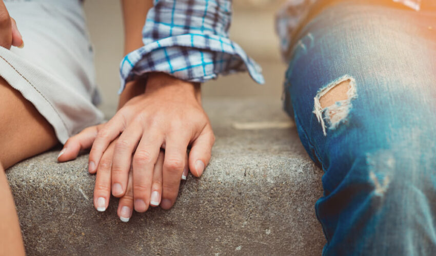 homme qui pose sa main sur celle d'une femme