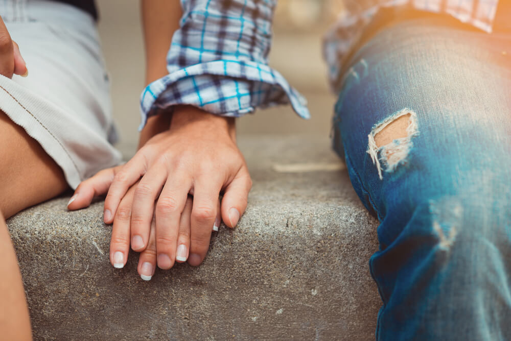 homme qui pose sa main sur celle d'une femme