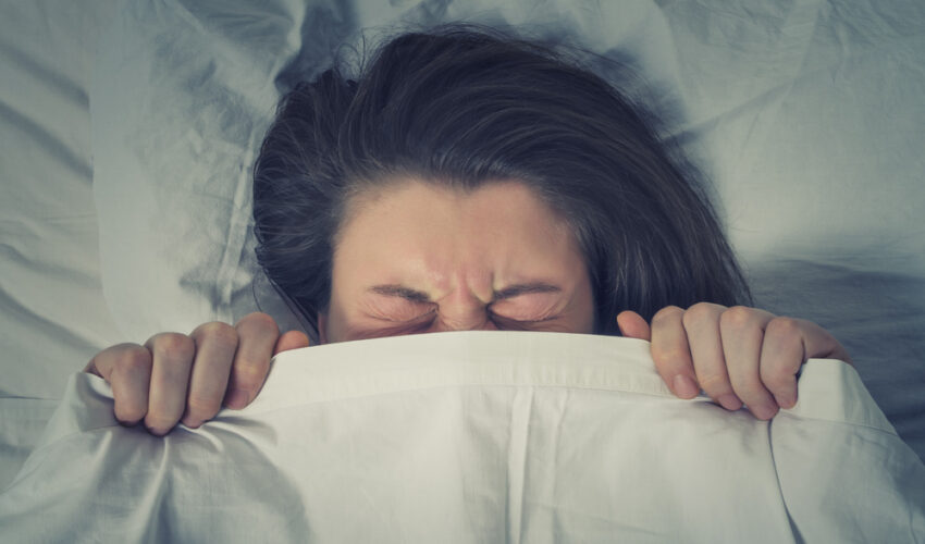 femme stressée sous une couette