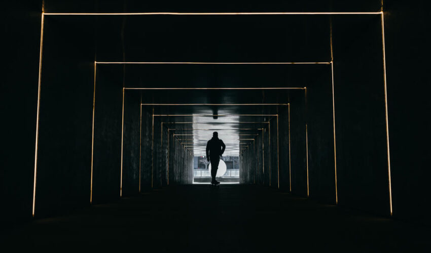 homme qui traverse un couloir obscure