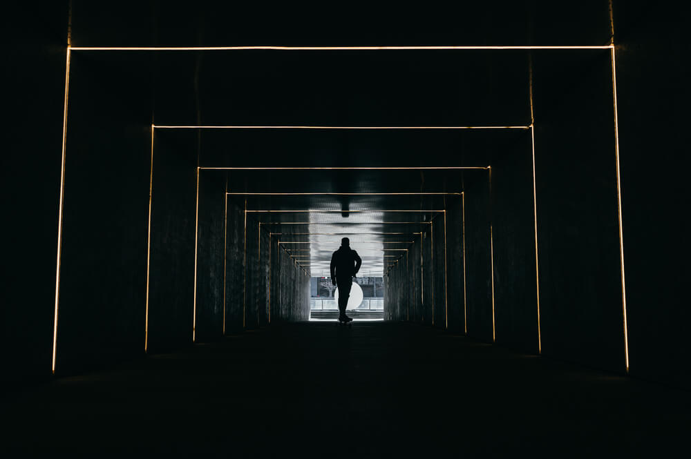 homme qui traverse un couloir obscure