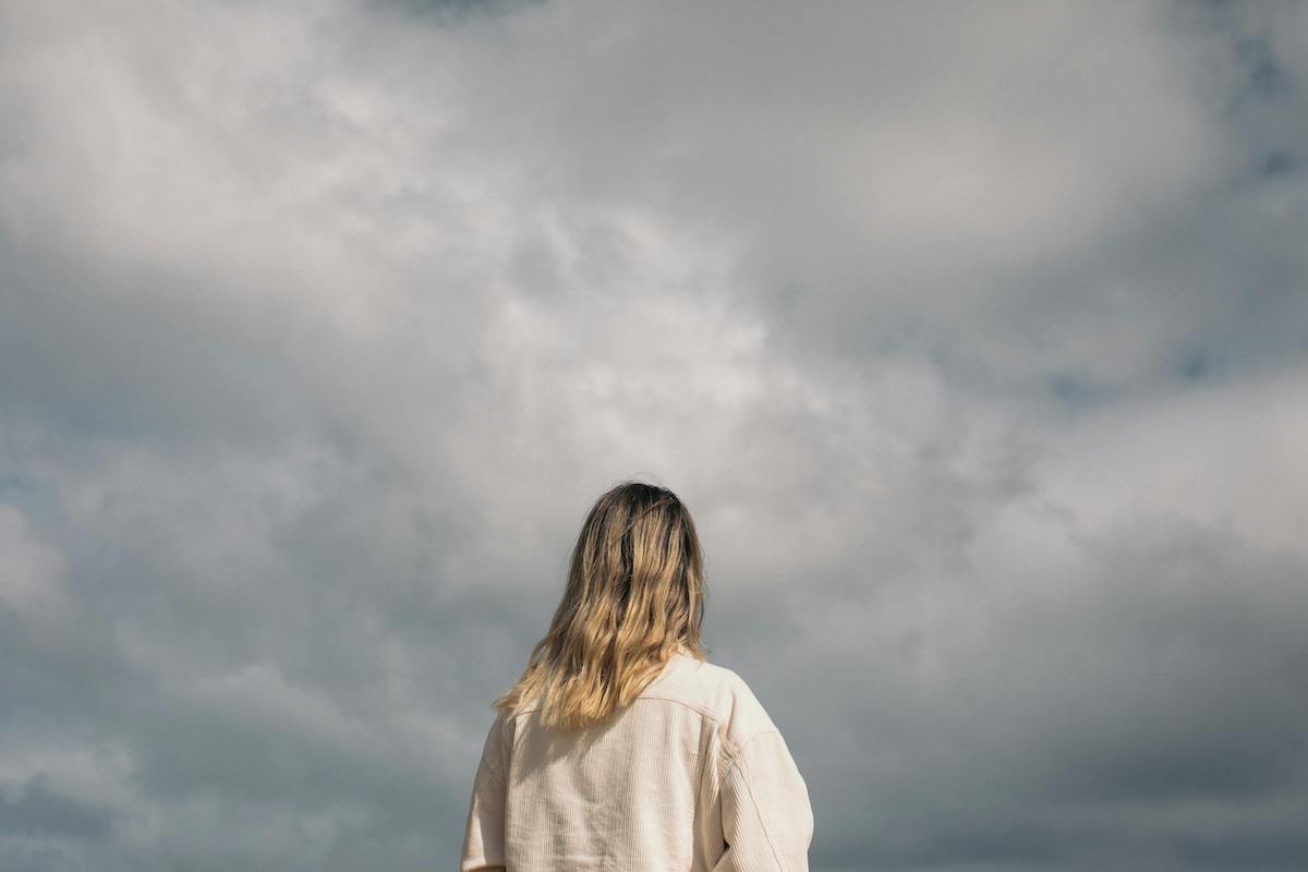 femme regardant le ciel gris