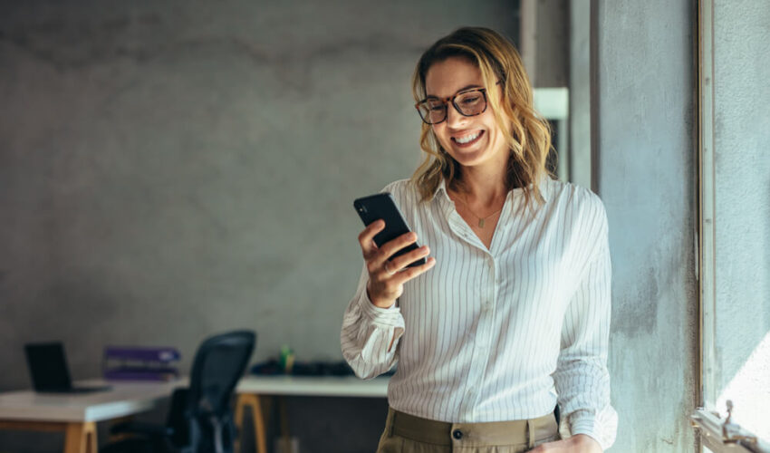 femme regardant son portable en souriant