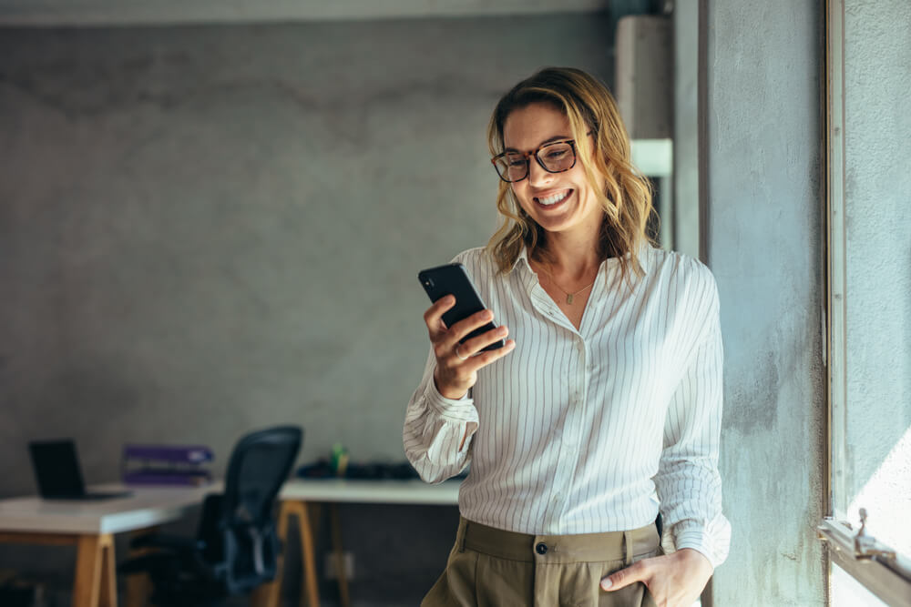 femme regardant son portable en souriant